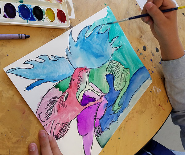 Student paints a dragon based on dragons from various worldwide cultures in Art History.